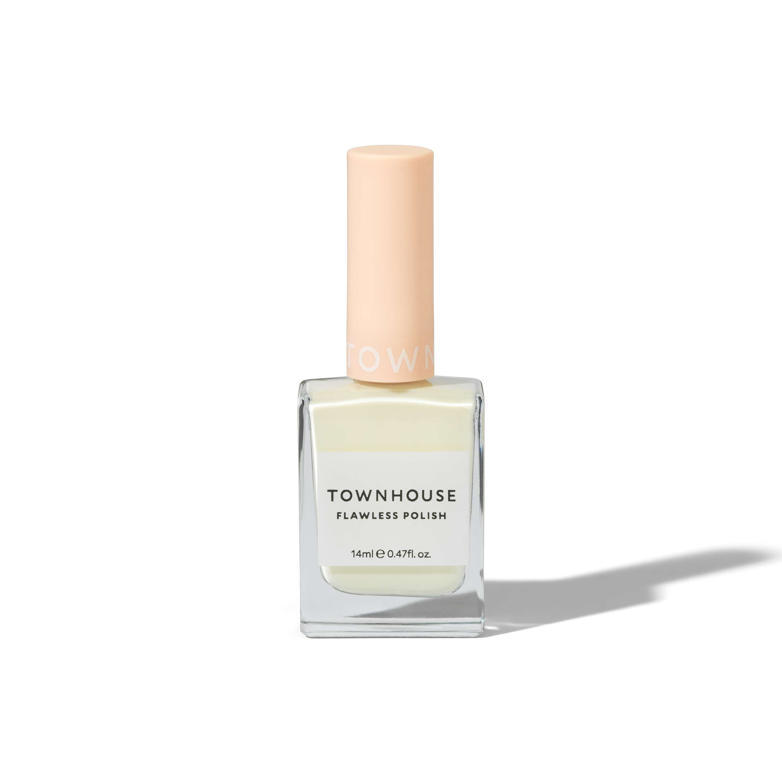 A bottle of TH - Coconut Milk Polish 14ml, featuring a pale peach cap and filled with creamy off-white polish, is set against a white background—the perfect choice for achieving a flawless manicure, whether worn alone or paired with your favorite base or top coat.