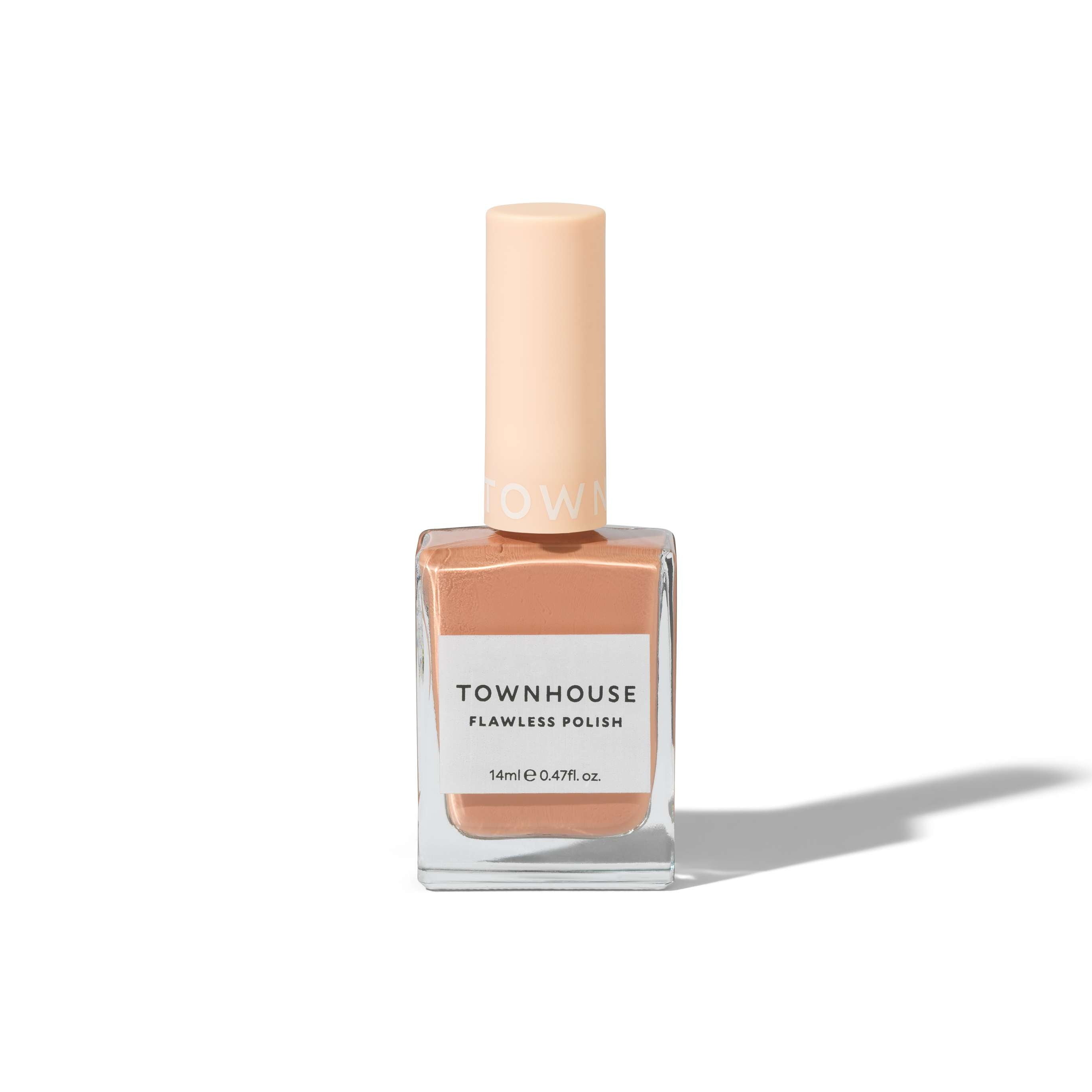 A bottle of TH - Croissant Polish 14ml in a pale peach shade, featuring a square glass base and a light beige cap, stands upright on a white background casting a delicate shadow. This elegant light brown nail polish offers subtle warmth and sophistication to any look.