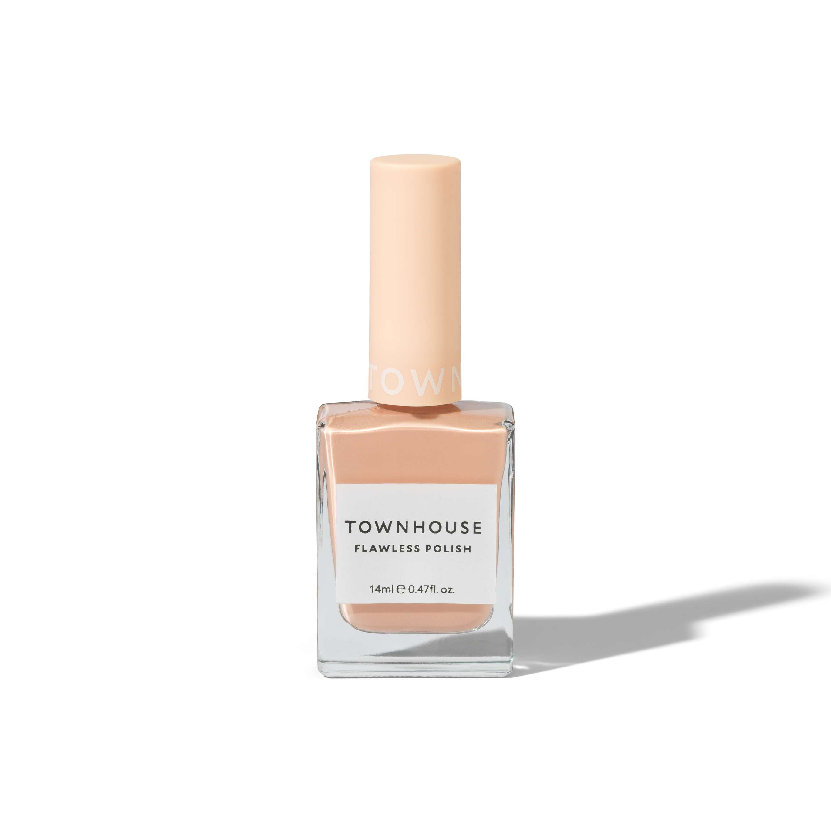 A bottle of TH - Chai Latte Polish 14ml, a creamy nail polish in a light peach shade, featuring a square clear glass base and a matching peach-colored cap, set against a plain white background.