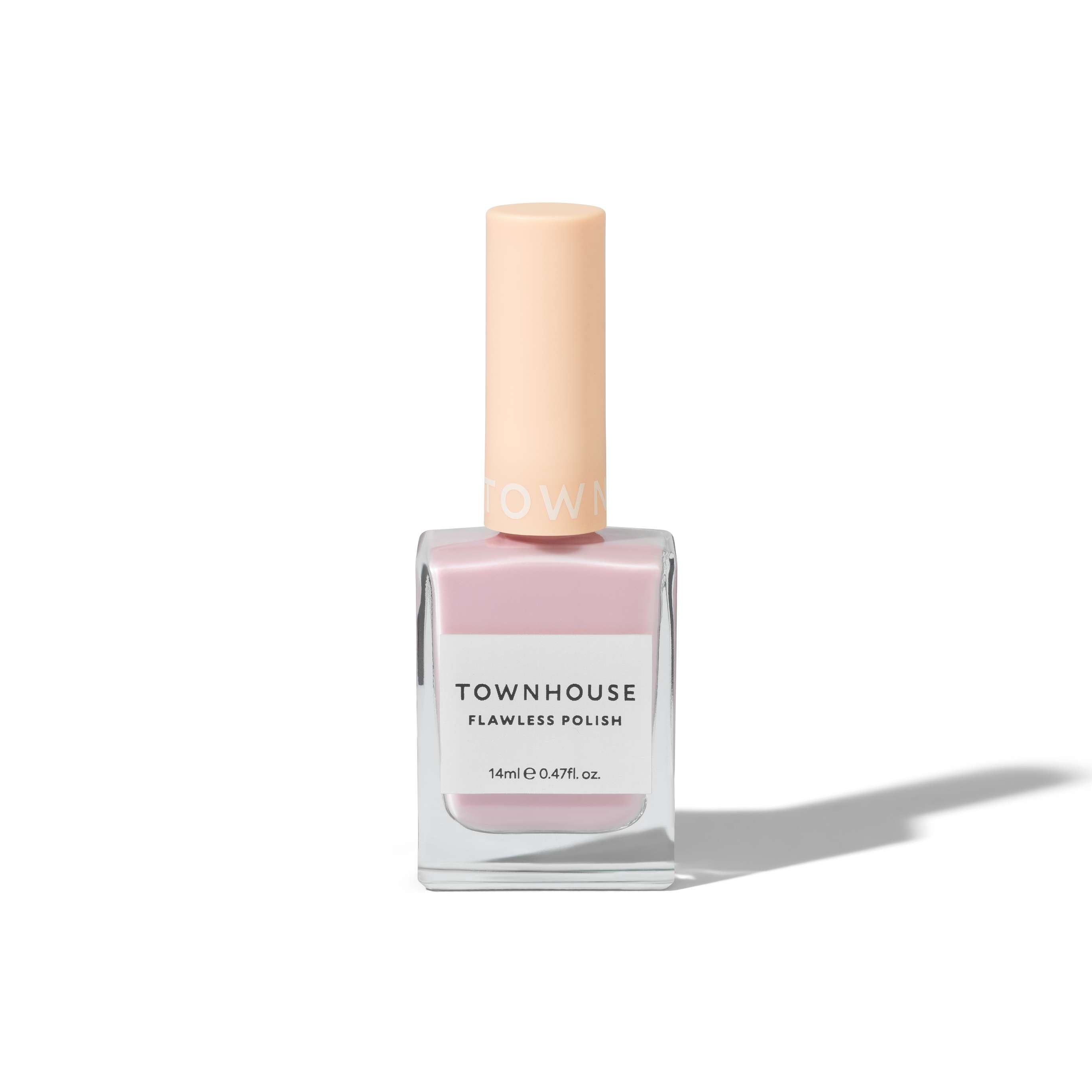 A bottle of TH - Milkshake Polish 14ml in a soft light pink shade, featuring a clear square glass base and a pastel peach cap, casts a shadow on a white background—making it the perfect choice for everyday nails.