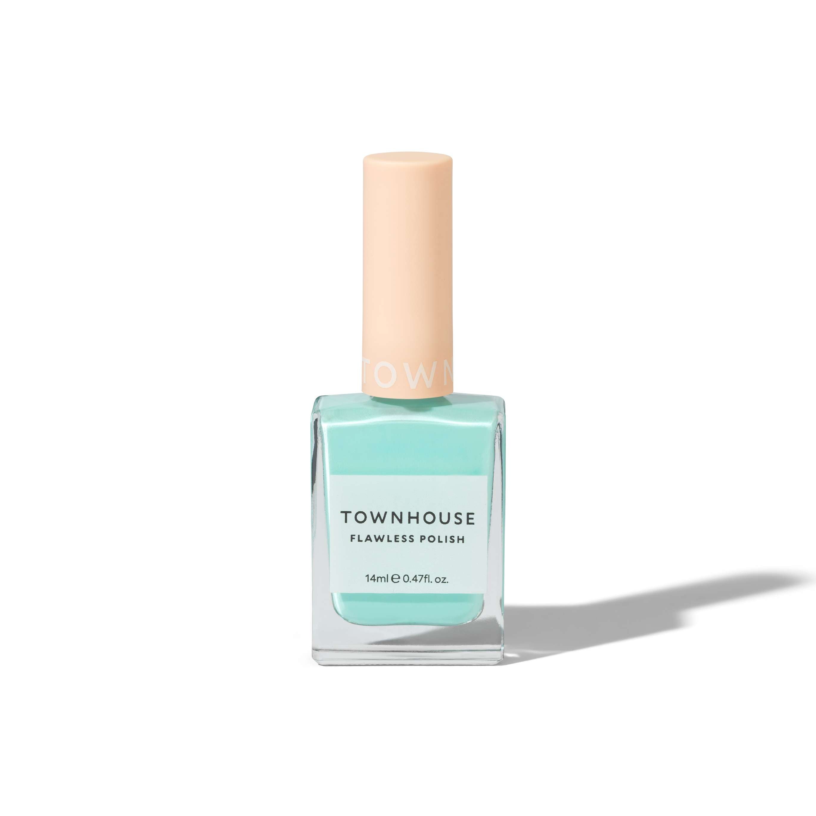 A bottle of TH - Pistachio Milk Polish 14ml nail varnish in a light aqua shade, reminiscent of milky green, with a peach-colored cap, standing upright on a white background with a soft shadow.