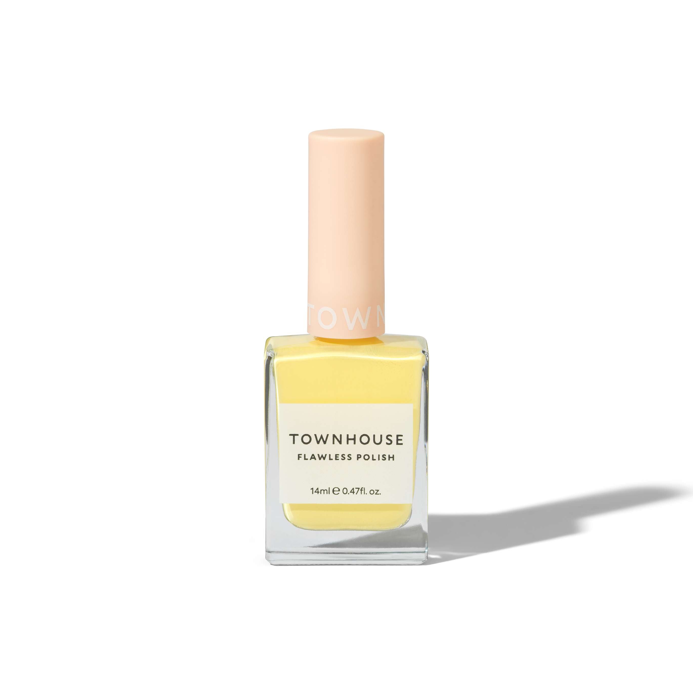 A bottle of TH - Butter Polish 14ml in pastel yellow, reminiscent of vintage nail polish shades, with a square glass base and a light peach cap, casting a faint shadow on a white background.
