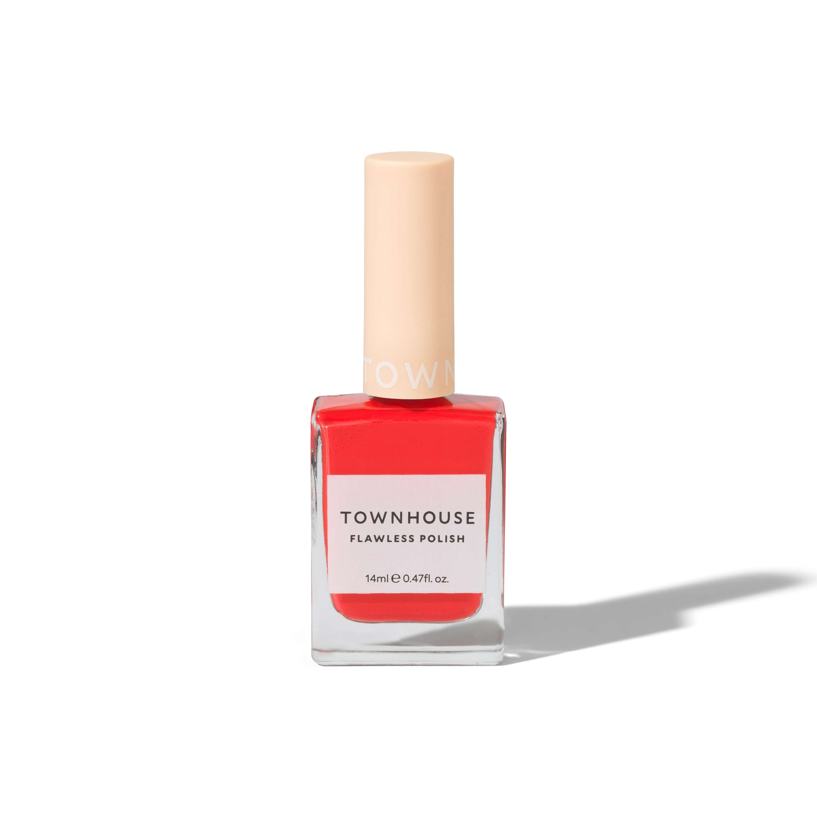 A clear glass bottle of TH - Tomato Polish 14ml nail polish in a bright coral shade, topped with a beige cap, stands upright on a white background—a perfect choice for achieving modern elegant nails.