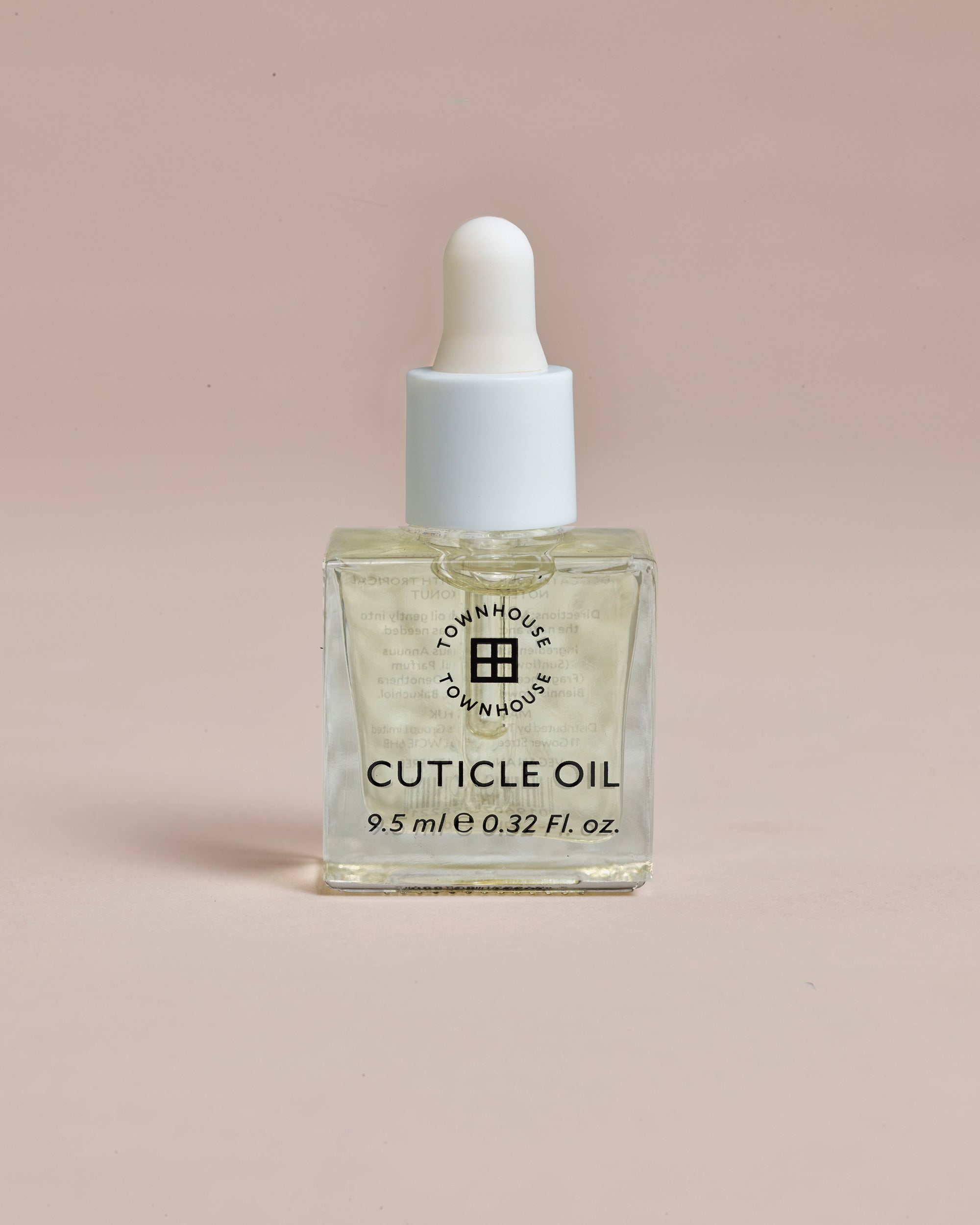A clear glass bottle of Townhouse Cuticle Oil 9.5ml, enhanced with nourishing squalene and topped with a white dropper cap, contains 9.5 ml (0.32 fl. oz.) of liquid and is displayed against a plain beige background.
