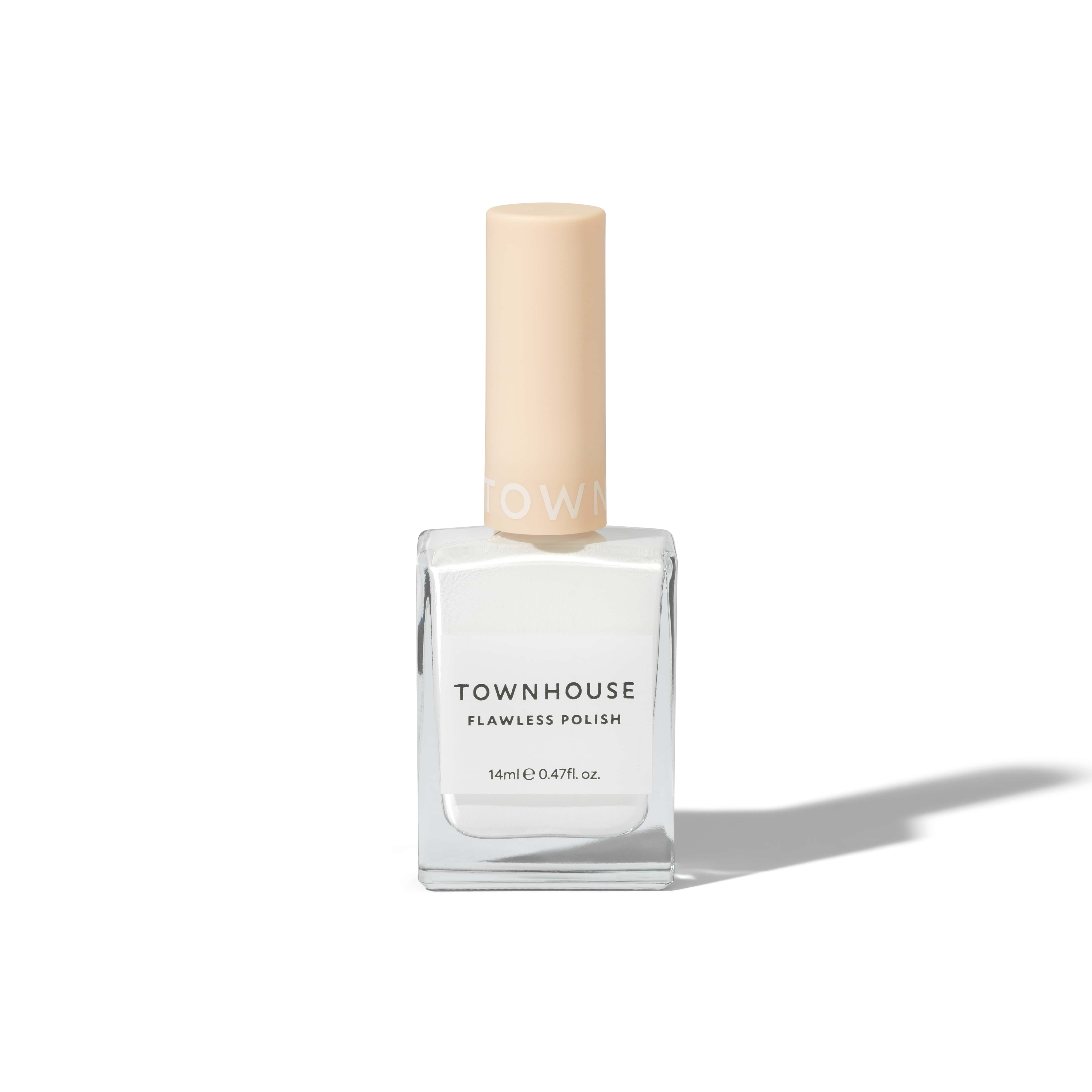 A clear glass bottle of TH - Meringue Polish 14ml, featuring whipped white nail polish that's perfect for creating elegant French tips, with a beige cap and casting a shadow on a white background.